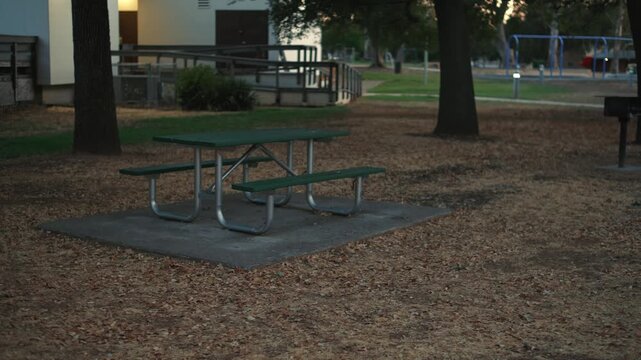 Empty picnic table in city park at sunset