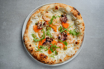 Fresh seafood pizza features shrimp and octopus on a creamy base, garnished with vibrant greens