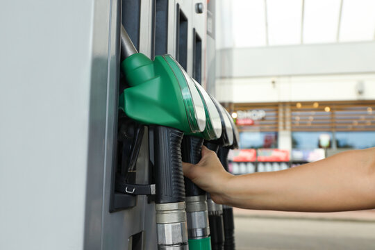 Customer refuels vehicle at a fuel pump station during the day