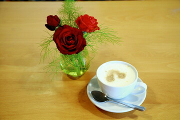 Red rose arrangement with morning coffee