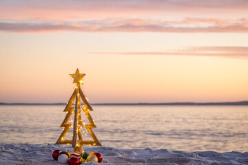 Simple rustic Christmas tree on a sandy idyllic beach
