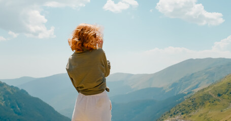 Woman traveler on top of mountain with picturesque landscape.