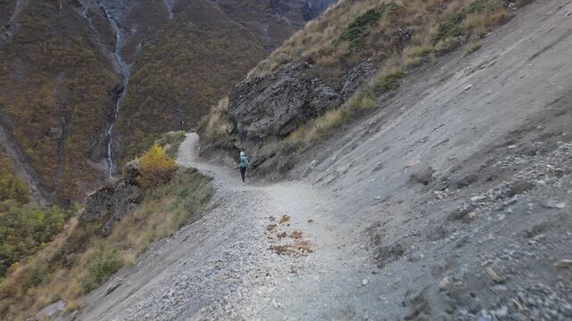 Undefined trekkers walking a precarious, high-altitude mountain path. Annapurna circuit way to Tilicho Lake in Nepal.
