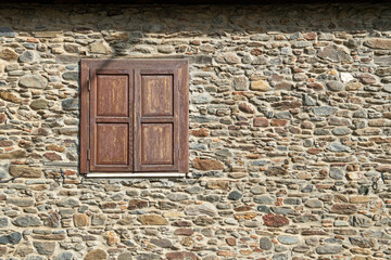 The harmony of wooden windows and stone walls. Stone-walled structures with wooden shutters. Historical stone structures with wooden shutters in Birgi Village in the Ödemiş district of Izmir. Türkiye
