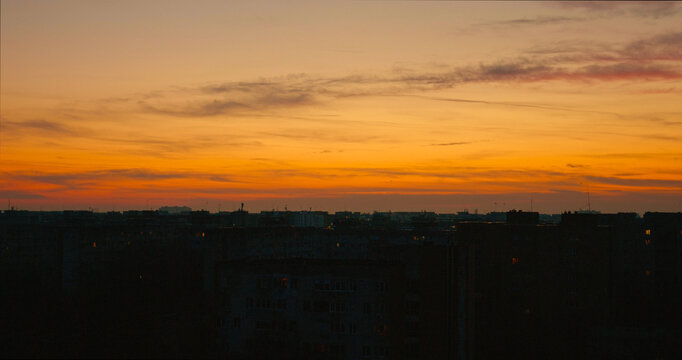 Rooftop view of urban landscape at sunset with city skyline in silhouette - Powered by Adobe