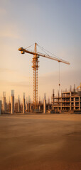Tower crane rising above an active construction site during golden hour, surrounded by concrete pillars and unfinished structures, capturing industrial growth under warm evening sunlight.