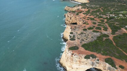 Rocky coastal cliff with natural arch in Faro, Algarve, Portugal