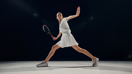 Female tennis player extended stance defensive position indoor match court. Concept of athletic control, readiness, technique in sport education, athlete analytics, and coaching resources.