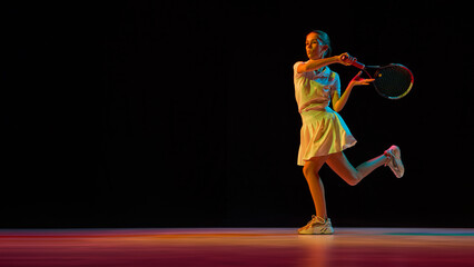 Female tennis player hitting backhand shot with power and determination. Concept of athletic performance, sports science, discipline training, and motivational fitness education.