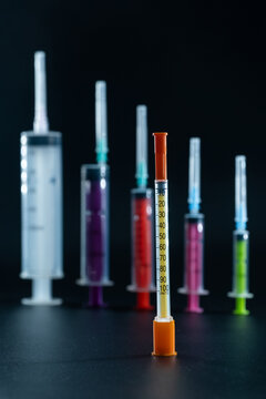 Thin insulin syringe contrasts with the bulkier syringes used for other medical procedures.