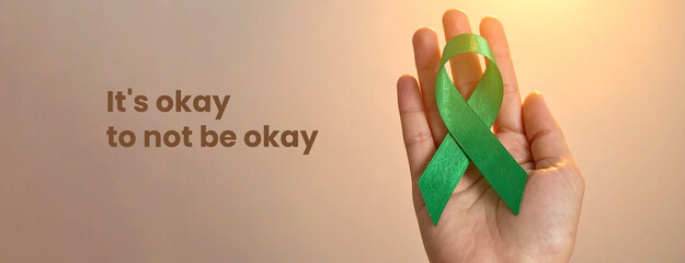 Hand Holding Green Ribbon for Men’s Mental Health Month