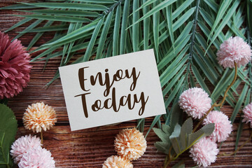 Enjoy Your Life Motivational and Inspirational quotes with flowers bouquet decoration on wooen background