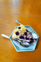 Blueberry cheesecake in blue dish at wooden table, Dessert
