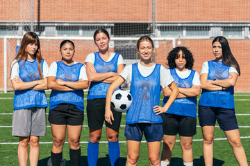 Diverse group of women athletes standing together on a soccer field, ready for training or a competition game