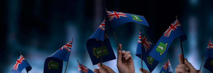 British Virgin Islands flags in their hands on a blurred urban background