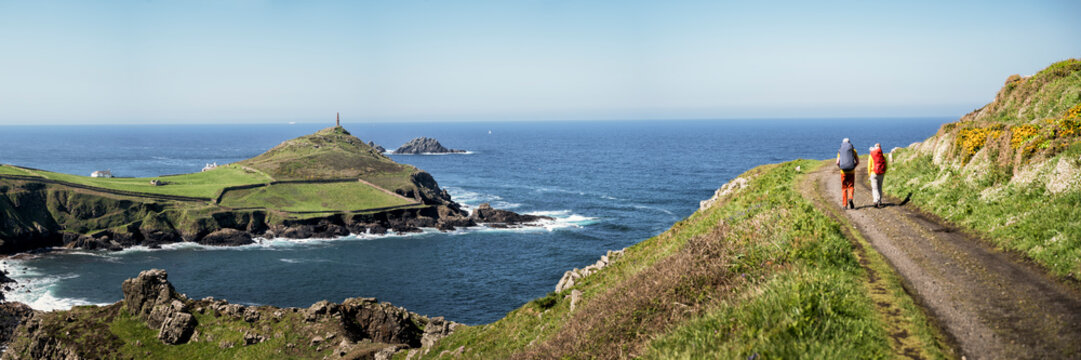 Two people hiking along coastal path at Karn Kenidjack Cornwall