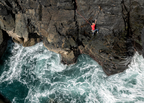 Climber on Mastadon E4 cliff above ocean at Gurnard's Head Cornwall