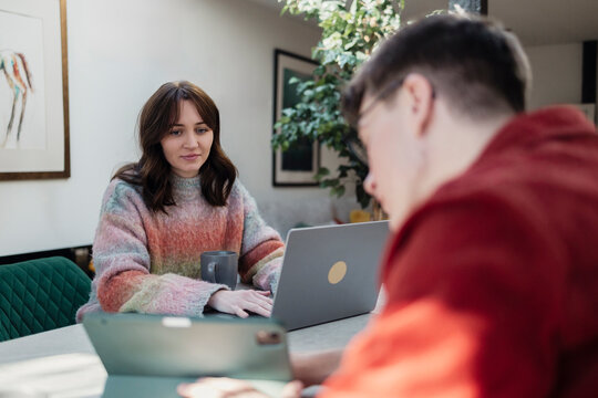 Couple working from home with laptops and tablet in a home office setting - Powered by Adobe