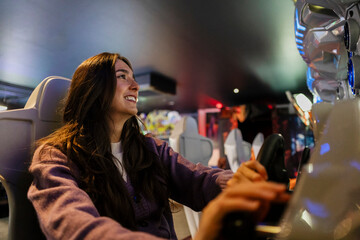Smiling woman playing arcade video game for fun and entertainment