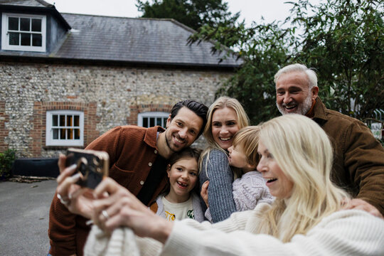 Multi generational family bonding outdoors while taking a selfie