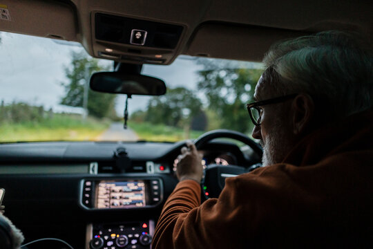 Person driving car on scenic road trip with navigation display