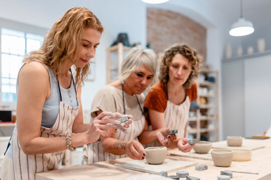 Friends enjoying pottery class and creating ceramic art at a workshop