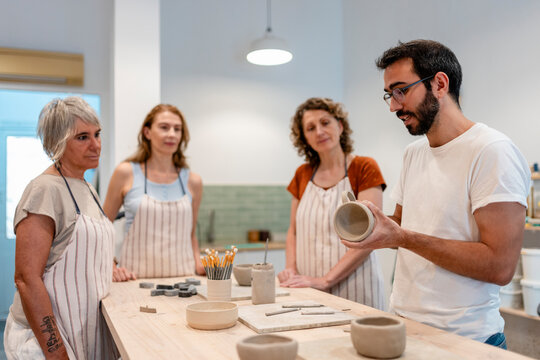 Pottery teacher demonstrating ceramic art in creative workshop