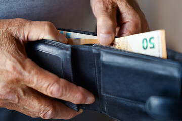 Hand holding euro banknote in wallet representing finance and savings
