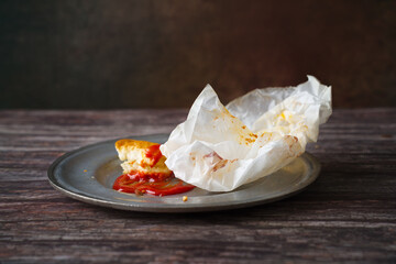 Messy leftover food with ketchup on dirty dish indoors