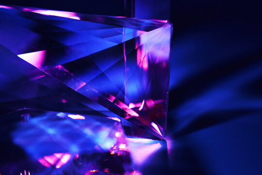 Abstract glowing glass prism with neon blue and magenta light reflection