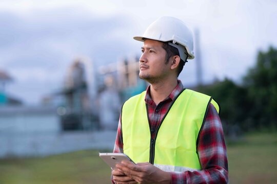 Engineer focusing on digital tablet to assess real-time data in a manufacturing facility, symbolizing precision engineering and productivity.