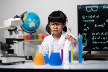 Young student performing chemistry experiment using colorful liquids in beakers, symbolizing creativity, discovery, and hands-on learning.