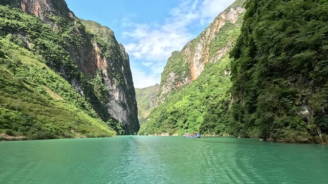 The Nho Que River flows between steep karst mountains in Ha Giang, Vietnam. Turquoise water, narrow canyon walls, and dramatic scenery create a stunning and immersive travel footage.