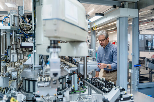 Engineer in modern factory working with industrial automation machinery