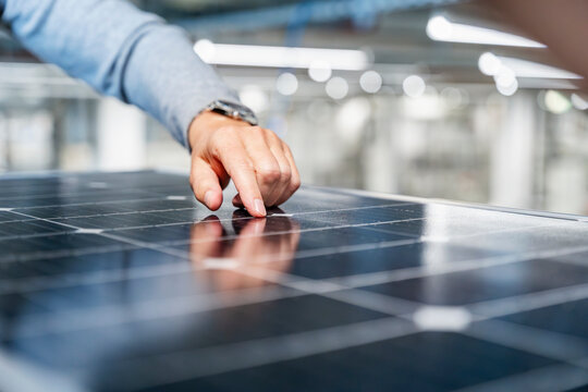Engineer inspecting solar panel in production hall