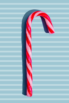Candy cane with red and white stripes on blue background
