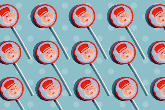 Santa Claus lollipops in festive pattern on blue background for Christmas