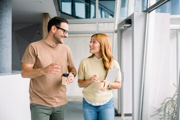 Colleagues talking and having lunch break while walking in office
