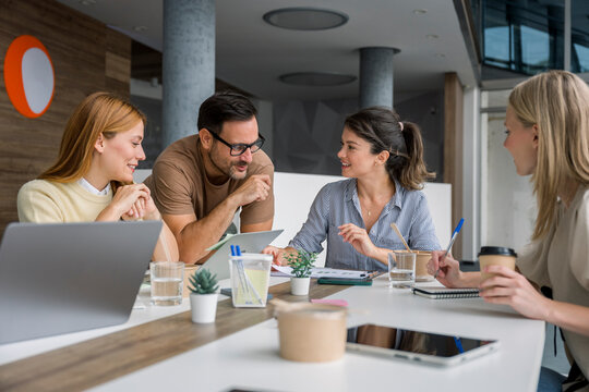 Business team meeting discussing charts using laptop in office