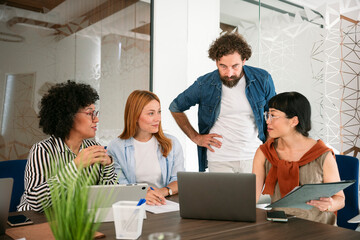 Business team discussion with digital devices in modern office workspace