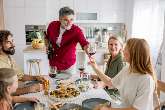 Family enjoying dinner and conversation in the kitchen at home