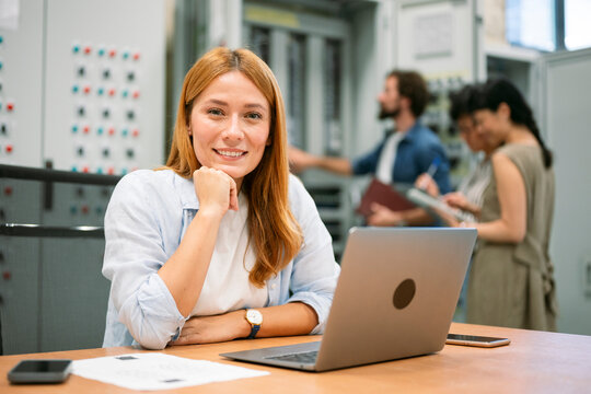Confident engineer looking at camera with laptop in workspace - Powered by Adobe