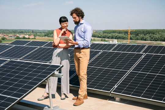 Business meeting outdoors using tablet at solar energy installation