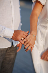 Couple holds hands showing love during sunset