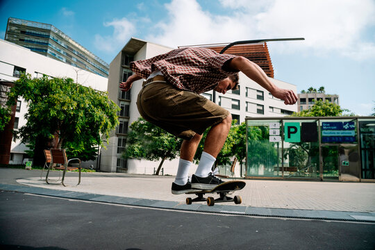 Skateboarder performing trick on urban street in Barcelona