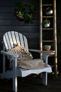 Deck chair and wooden ladder with coffee pot and wreath in autumn garden
