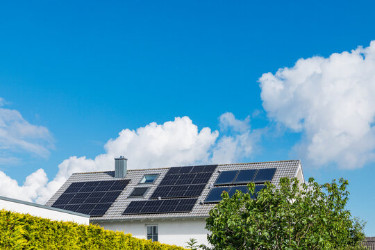 Residential house in Cologne with solar panels on roof under blue sky