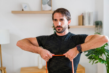Focused individual performing resistance band exercise at home