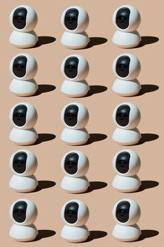 Grid of modern white surveillance cameras under studio lighting