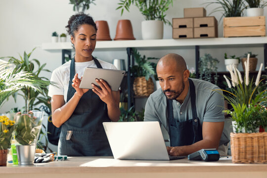 Entrepreneur couple working together in plant store with technology